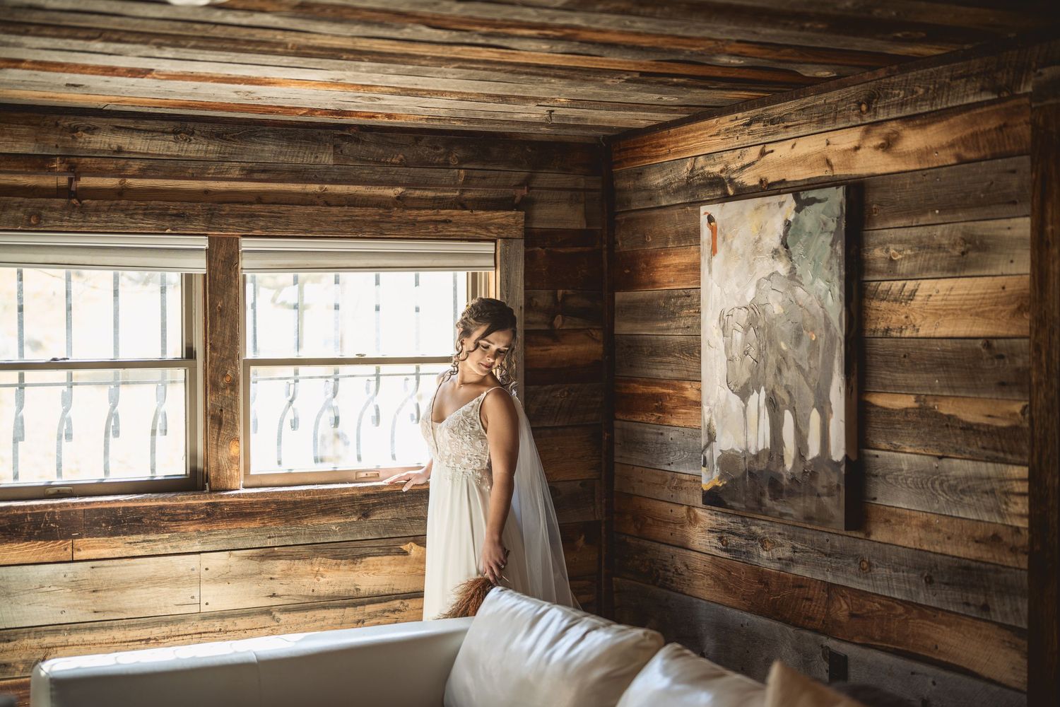 Interior view of a rustic wooden cabin with natural light streaming through windows.