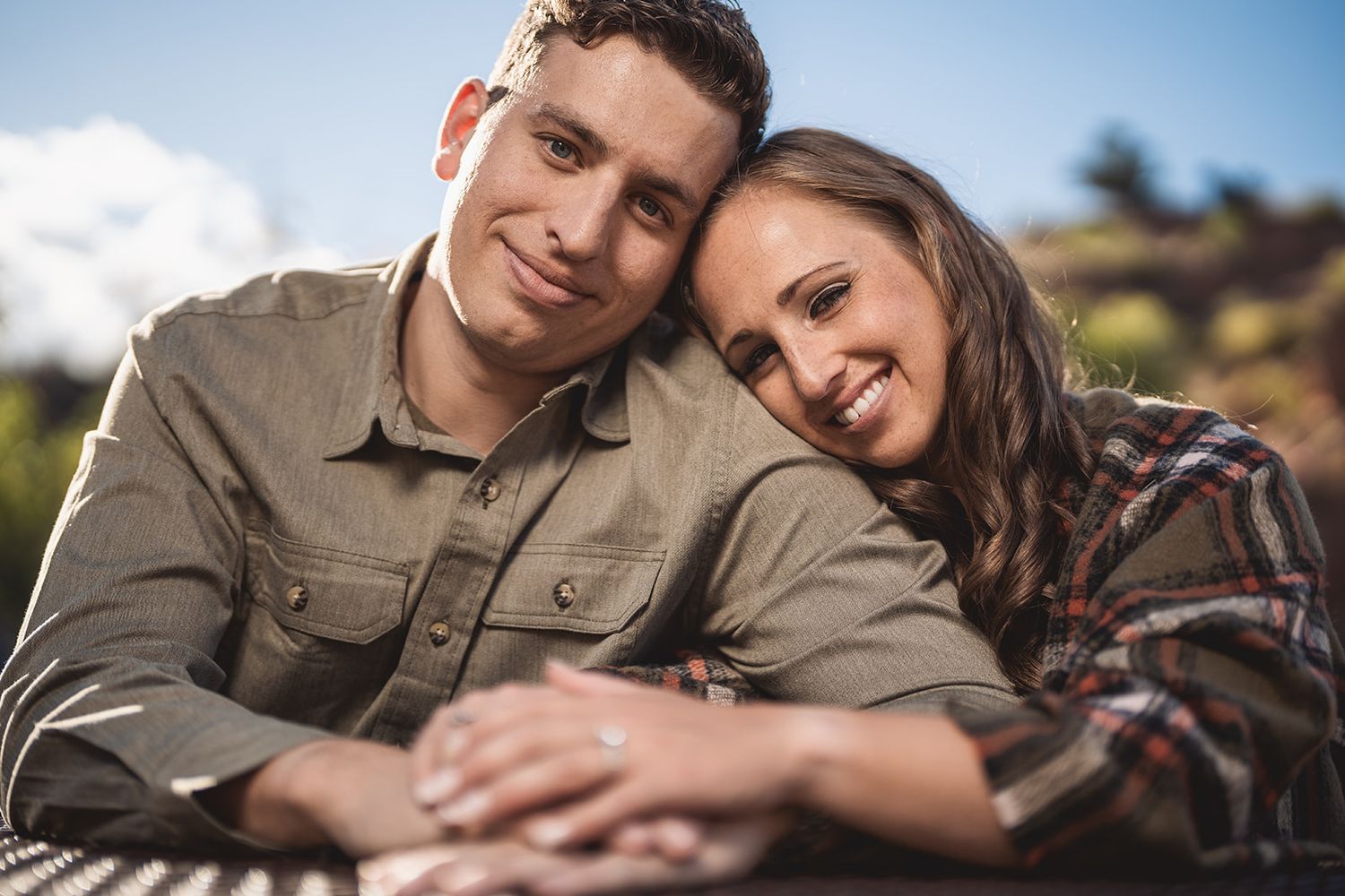 Loving couple embraces while enjoying a tender moment outdoors in natural lighting.