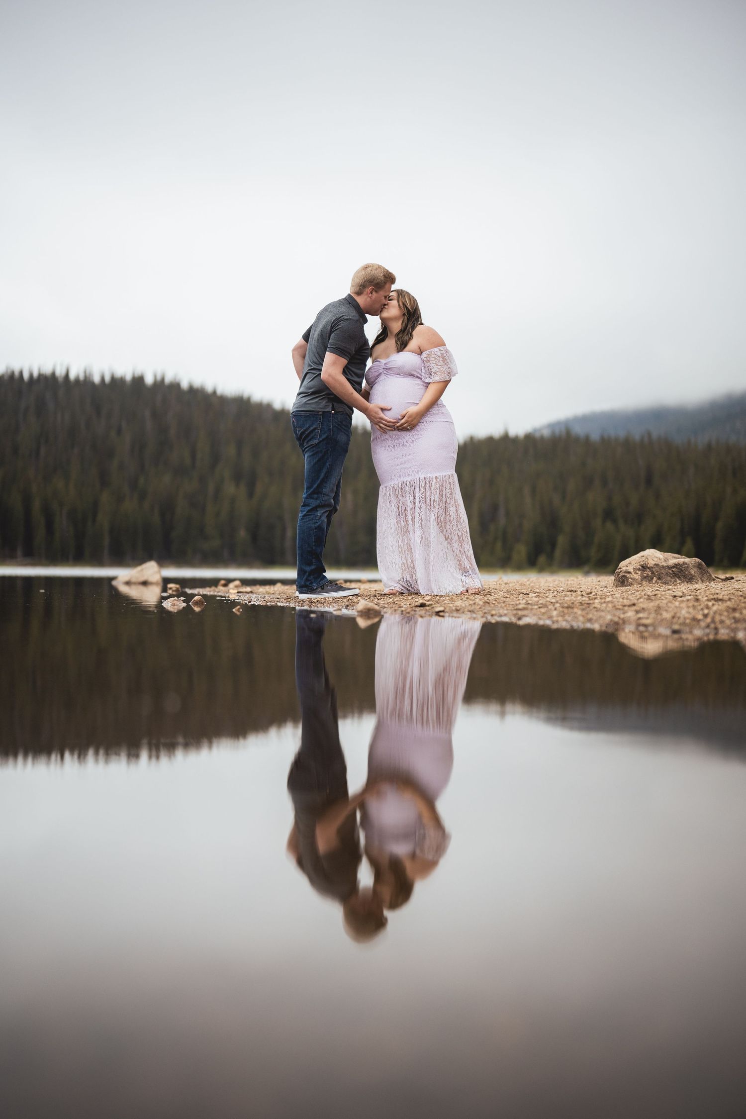Intimate lakeside portrait session with reflection in still mountain water.