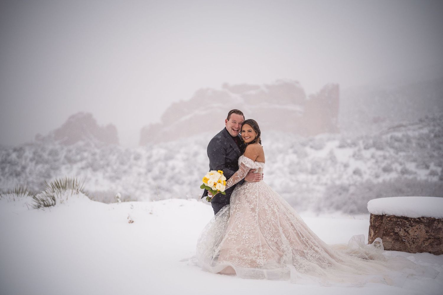 A romantic winter wedding photo shoot in a snowy mountain landscape with a pink ballgown dress.