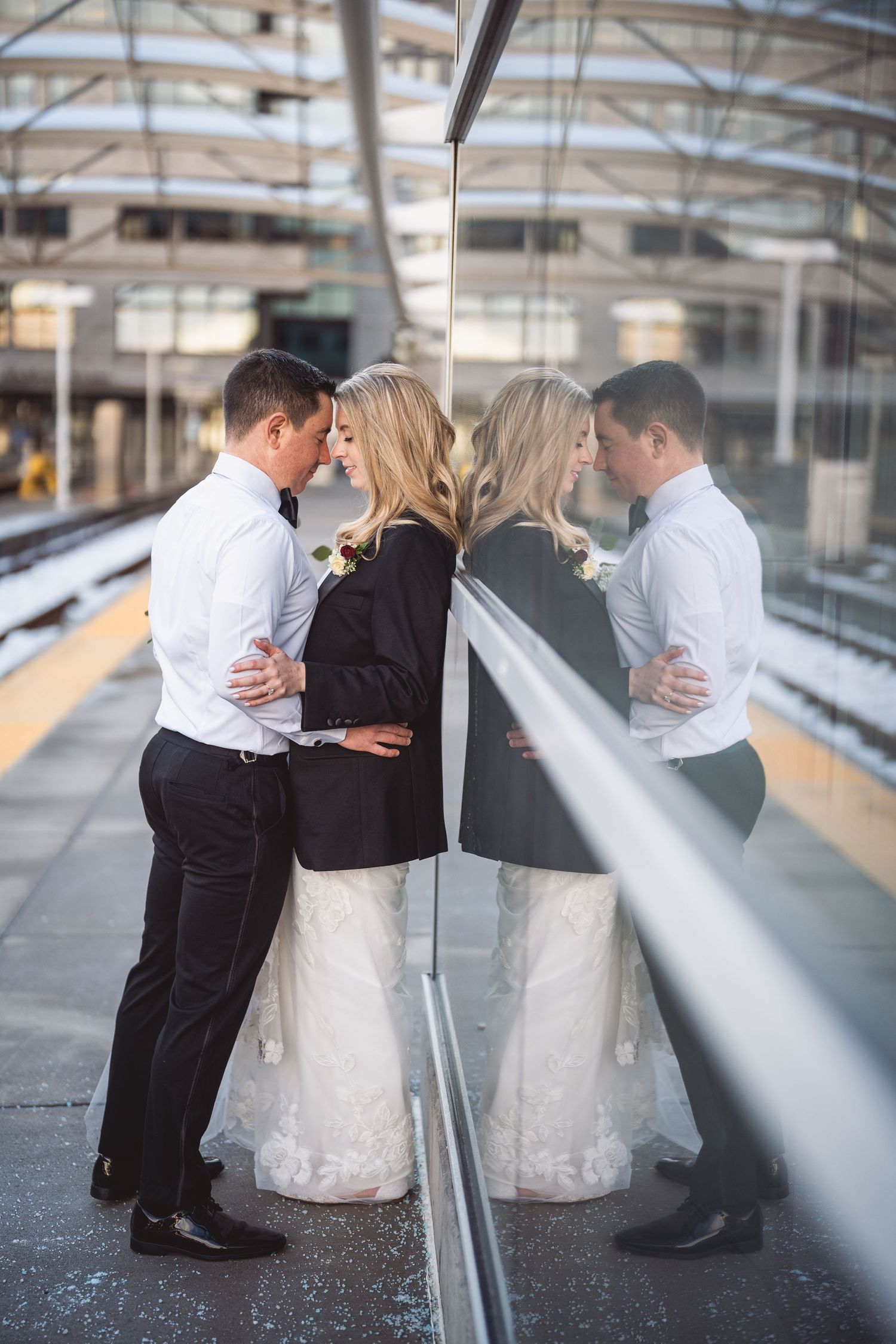 Wedding couple embraces on a modern industrial platform with dramatic lighting.