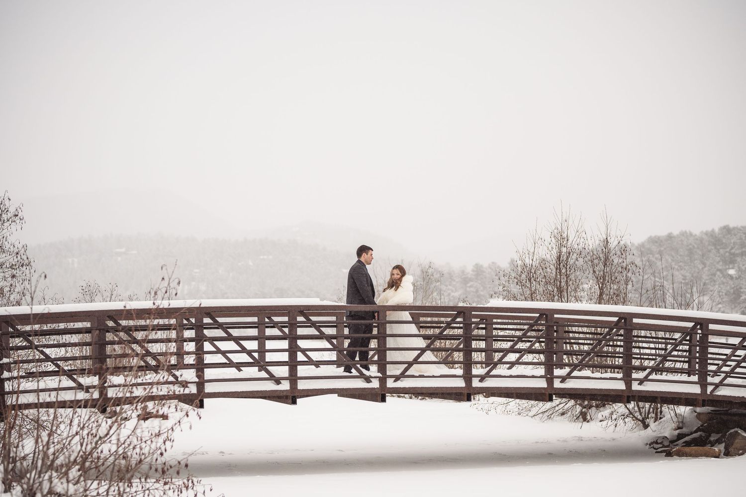 A scenic winter bridge at a mountain venue dusted with snow.