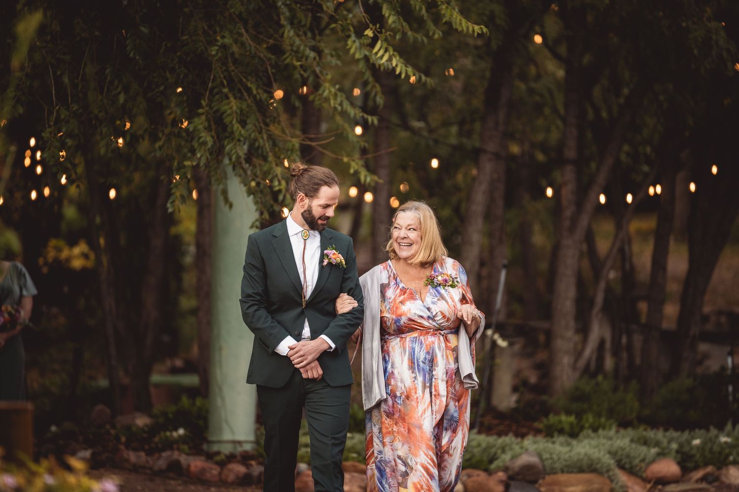 Outdoor evening event with string lights illuminating a garden pathway.