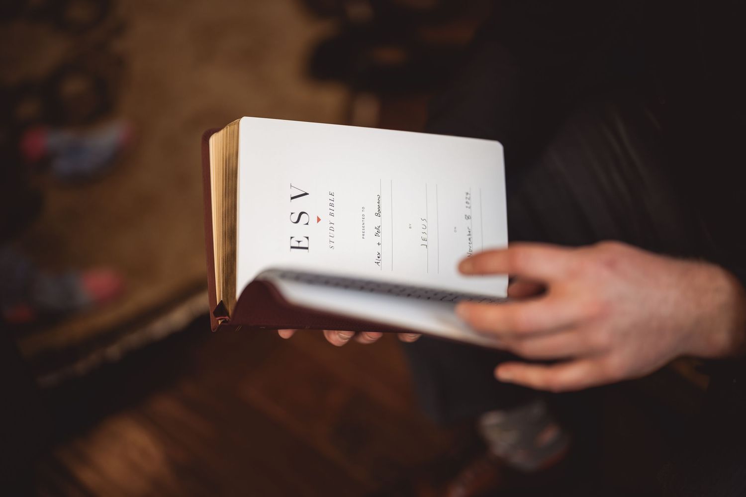 Paper and envelopes displayed on a dark wooden surface with hands visible at the edges.