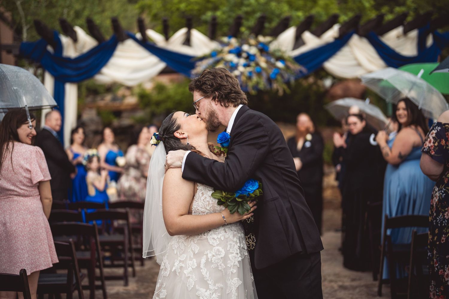 A wedding ceremony moment captured on a rustic stone patio surrounded by greenery.