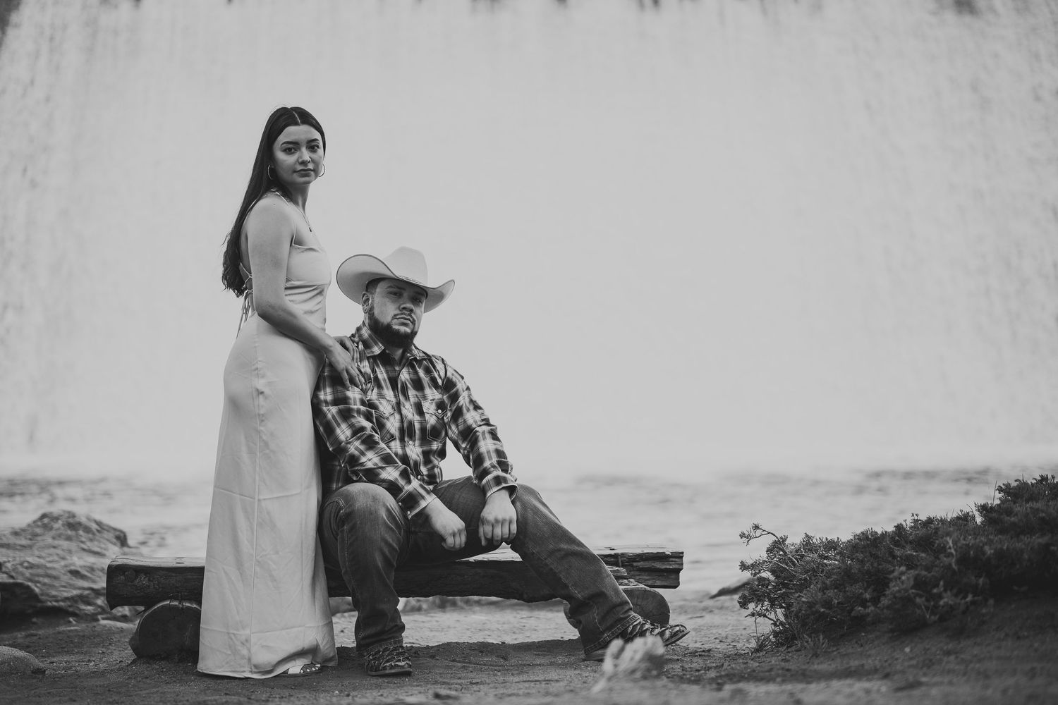 Artistic black and white engagement photos taken against a textured wall.