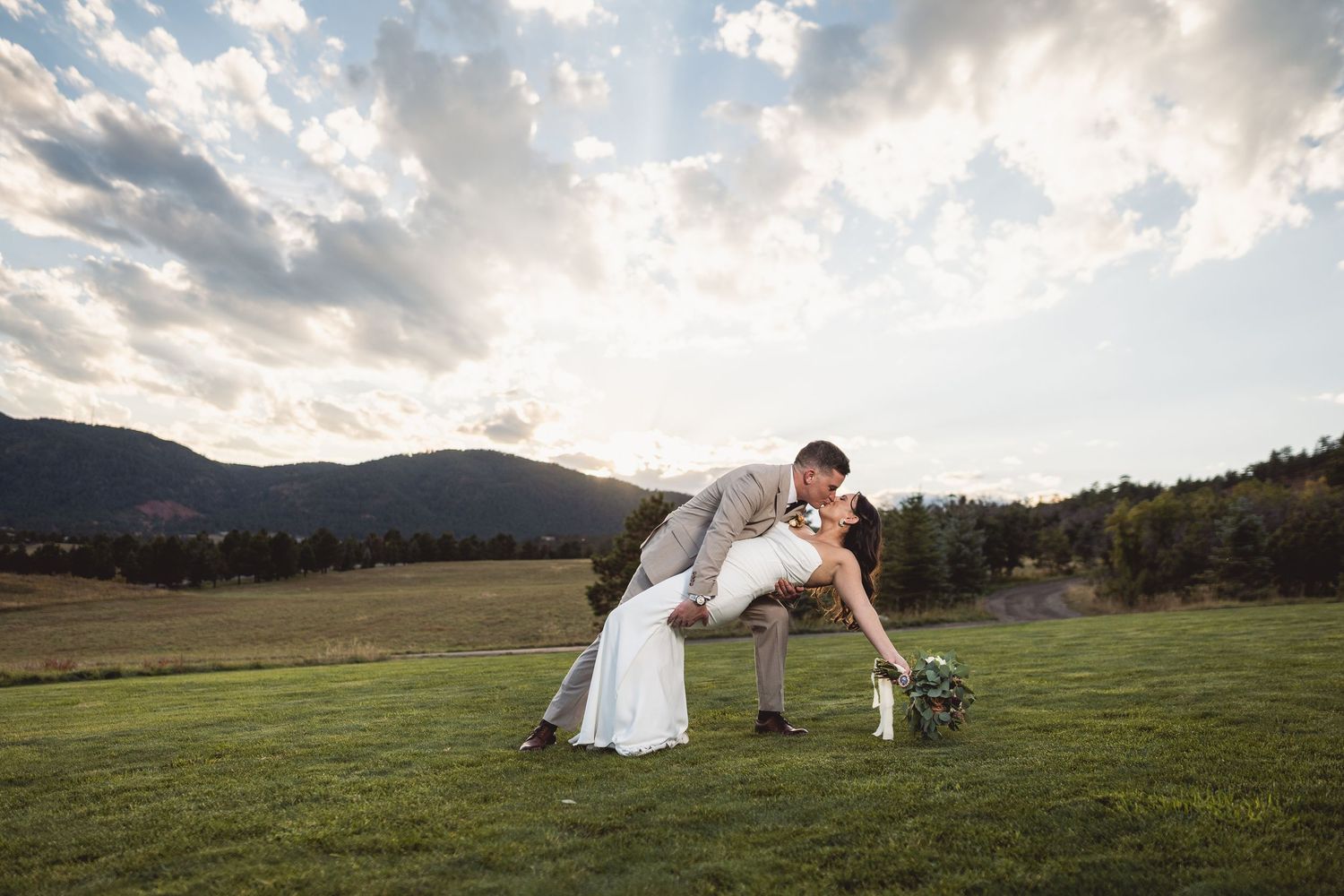 Dramatic wedding portraits against mountain landscape at golden hour.