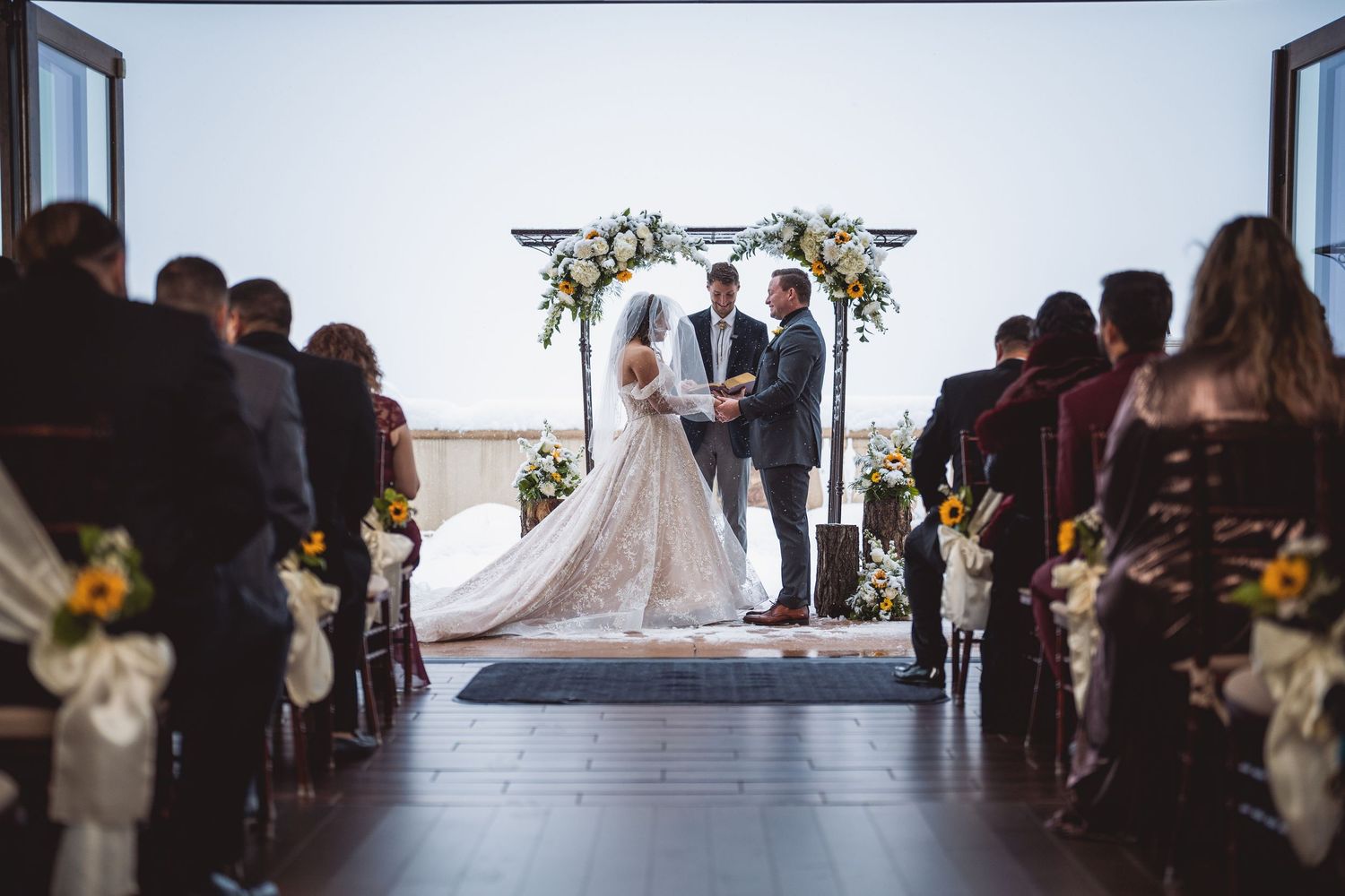 Wide-angle view of a wedding ceremony with guests seated in rows facing the altar.