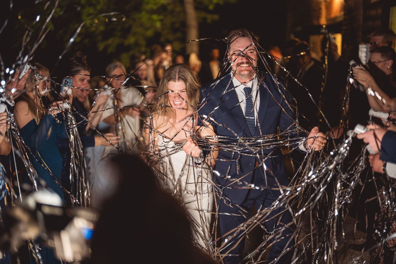 Wedding guests celebrate with sparklers creating a magical nighttime atmosphere.