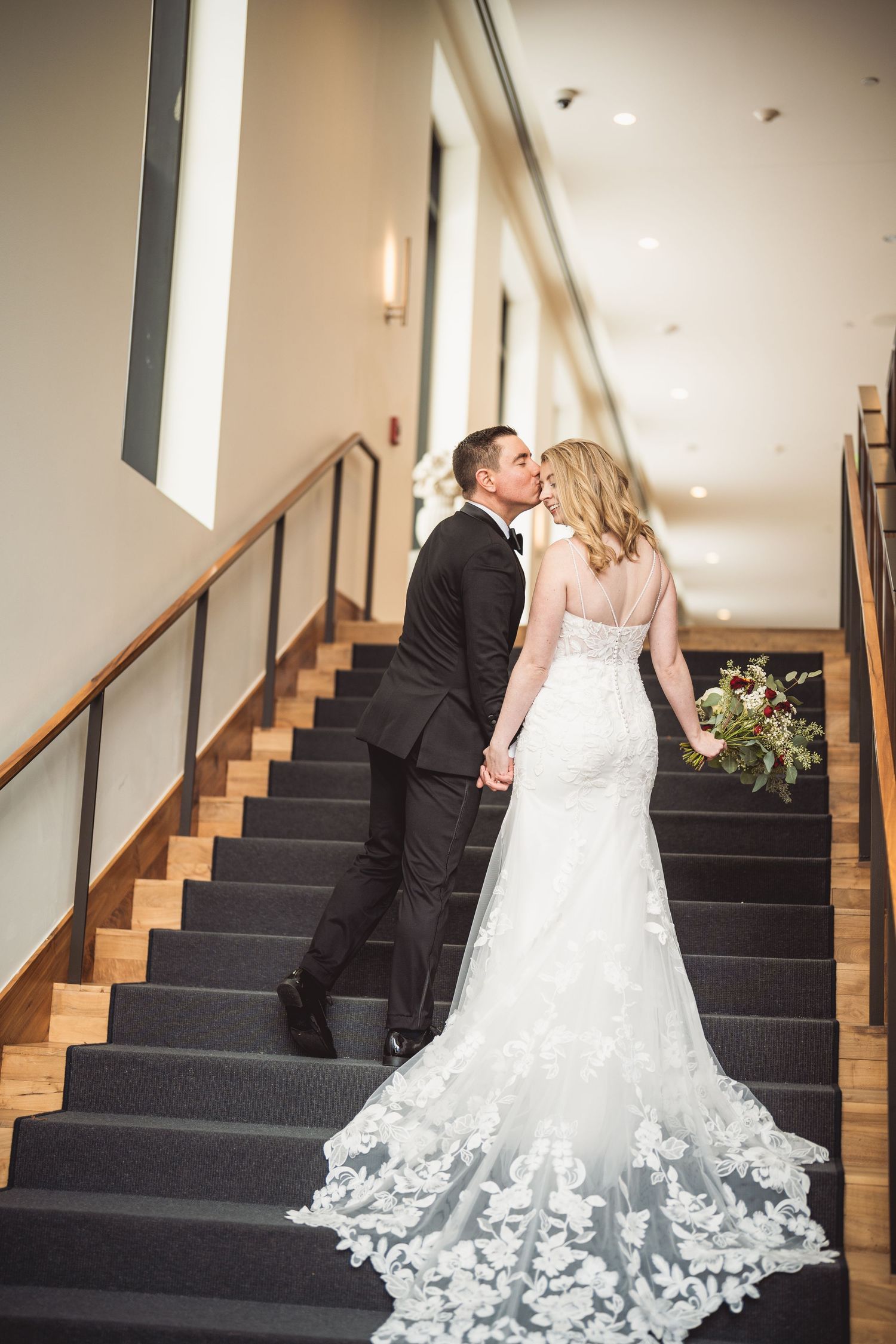 A romantic wedding couple sequence showing playful interactions on carpeted stairs.