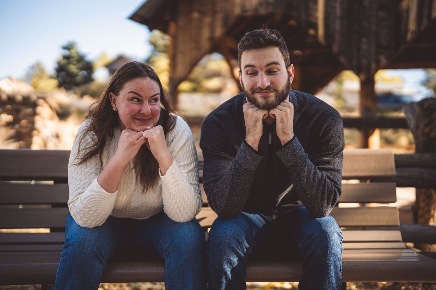 Casual outdoor portrait session on wooden bench with natural lighting.