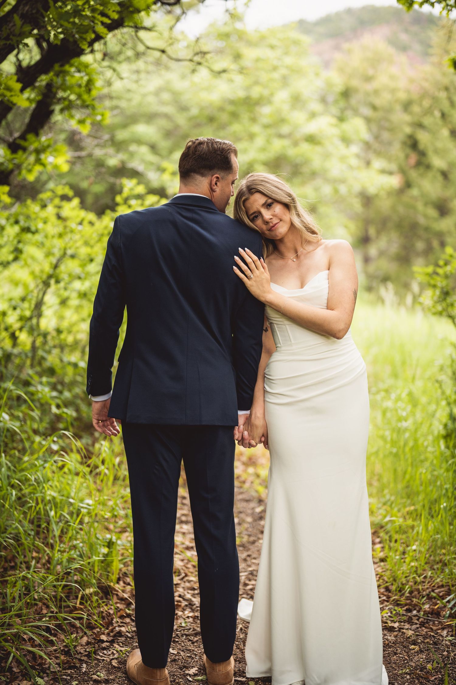 Wedding couple shares tender moments in a series of intimate poses against a natural backdrop.