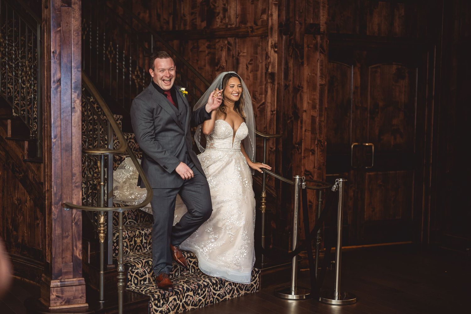 Wedding reception dance captured in a rustic venue with wooden beams and warm lighting.
