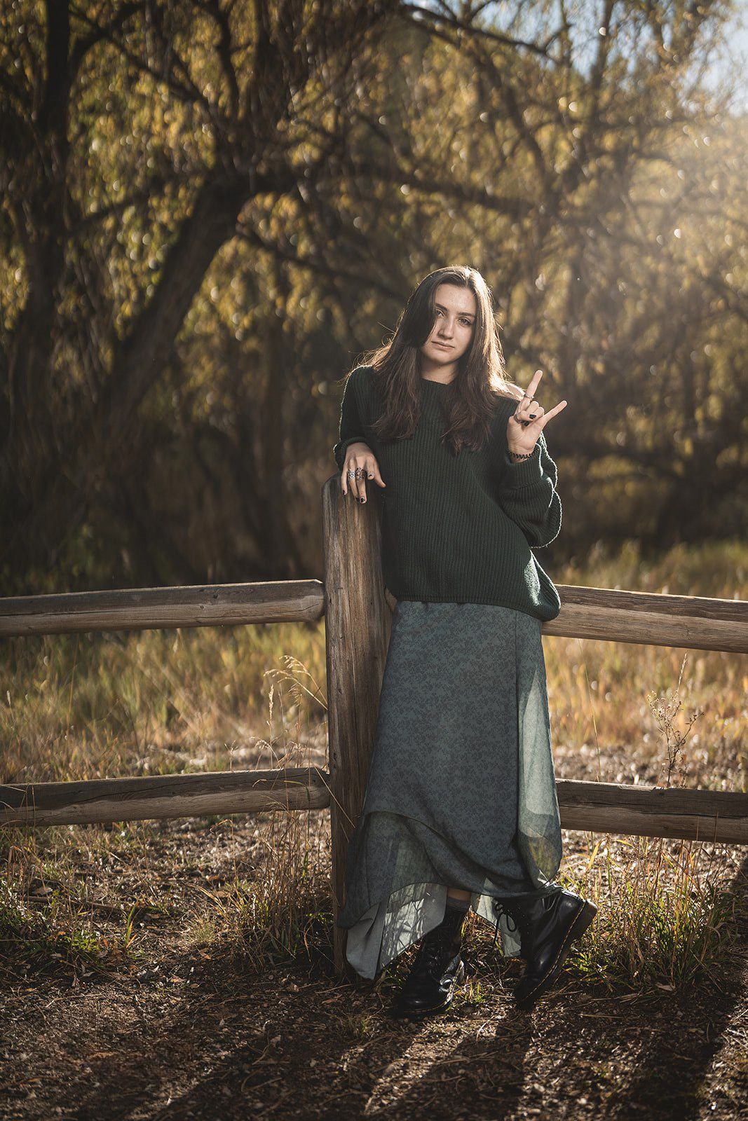 Sunset portrait session in a natural setting with golden light filtering through autumn trees.