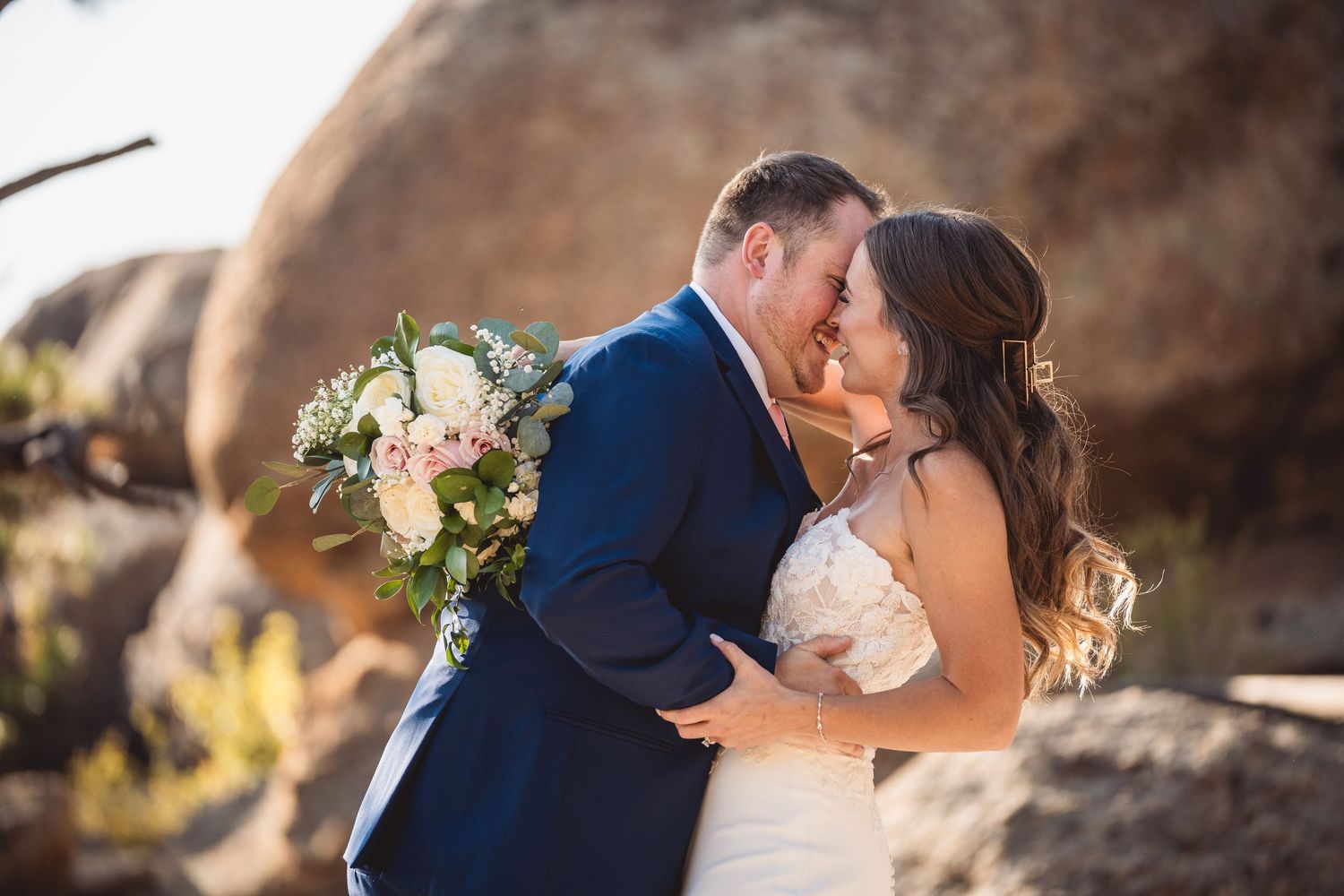 A romantic wedding portrait captured among rocky natural scenery.