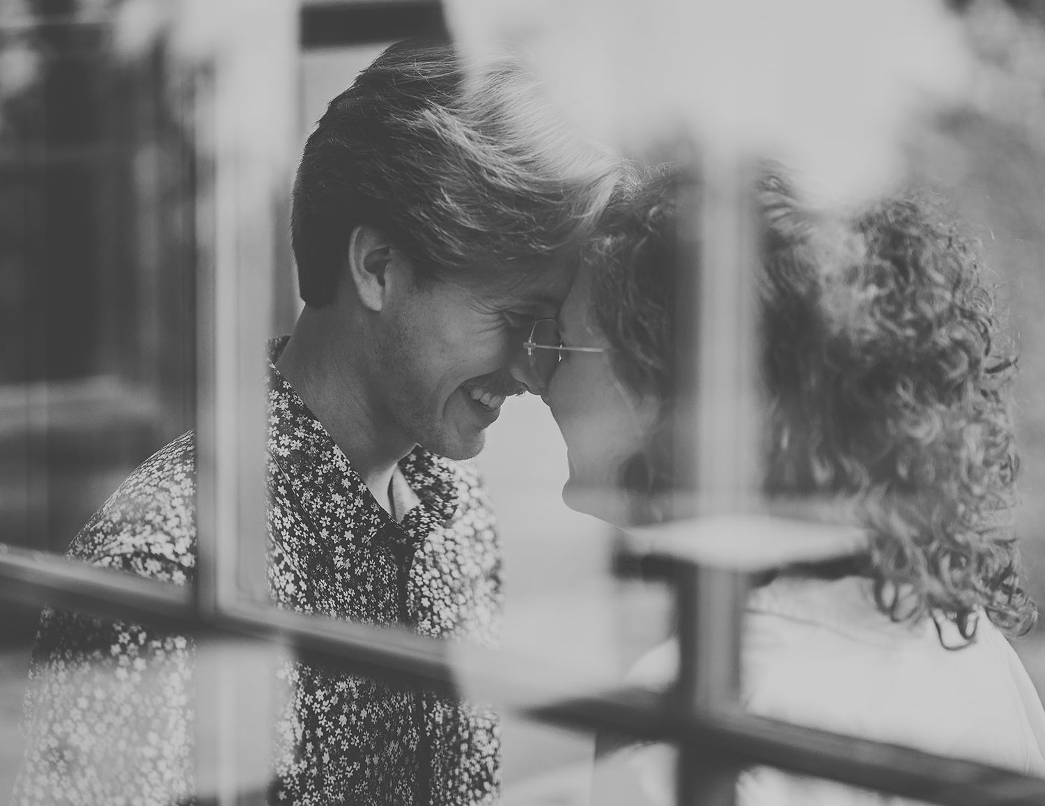 Black and white series of romantic close-up moments between a couple against a blurred background.