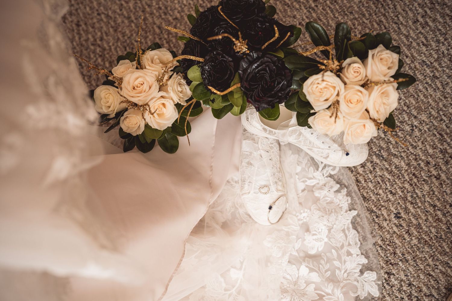 Cream-colored roses arranged on textured fabric create an elegant wedding detail.