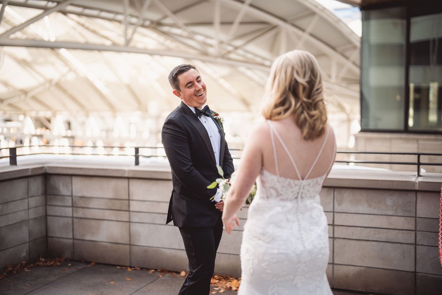 Couple shares romantic moment in wedding attire on outdoor terrace.