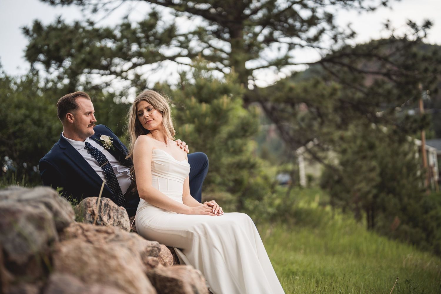 A mountain wedding portrait session with pine trees and rocks in the background.
