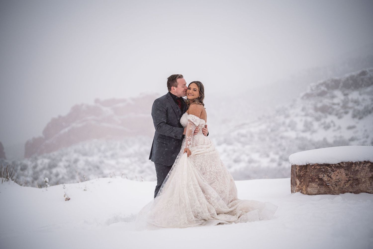 Couple shares intimate moments during winter wedding photoshoot in snow.