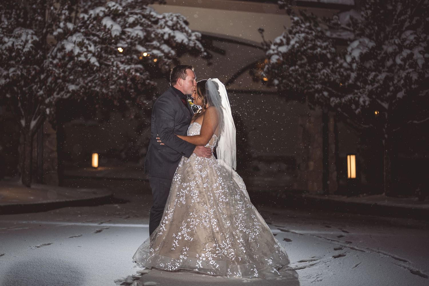 Bride and groom share a romantic first dance outdoors in the snow at their winter wedding reception.