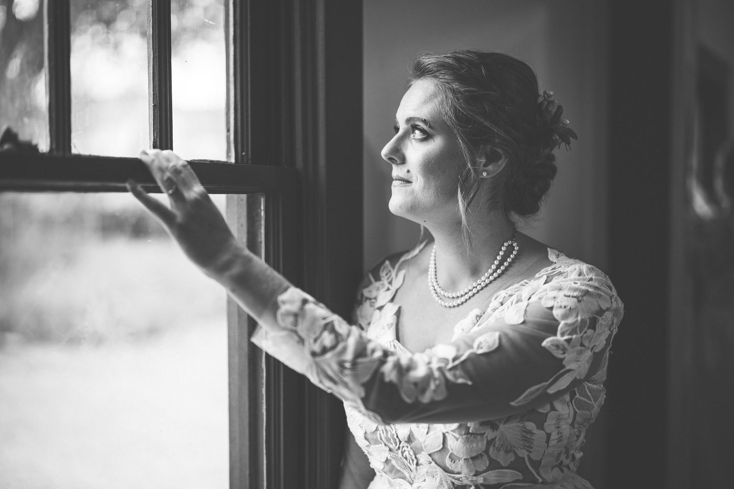 Artistic black and white bridal portrait series by a window with natural light.