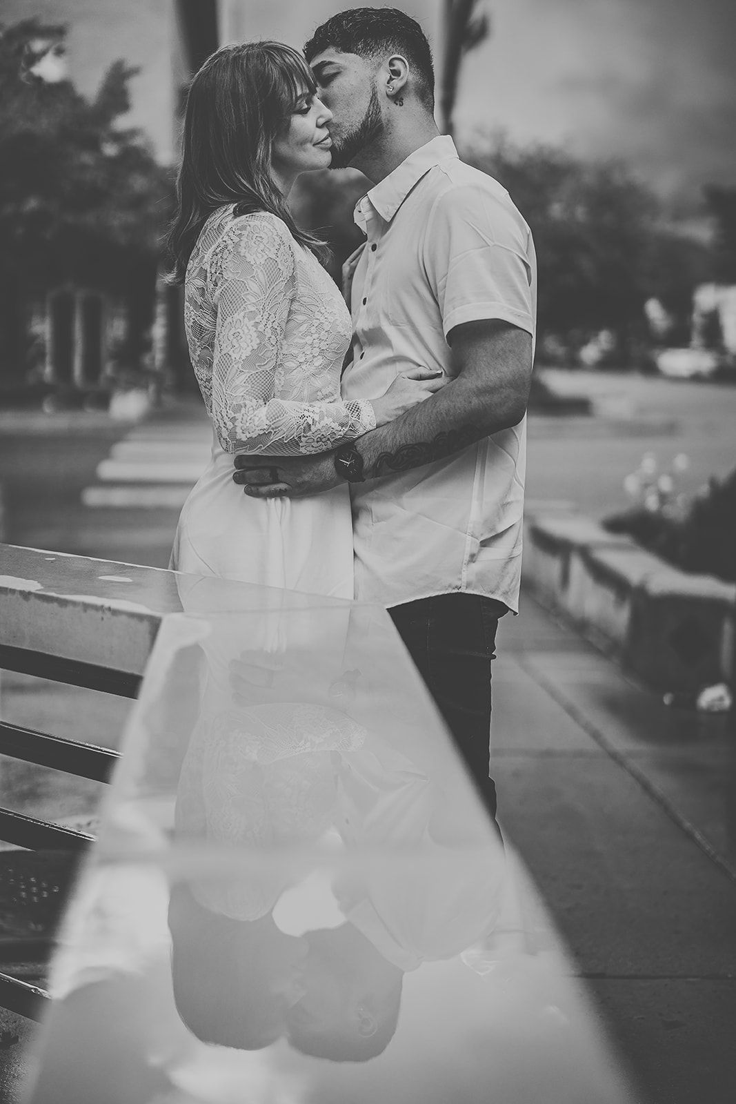 Romantic black and white wedding photos showing tender moments between a couple by a car.