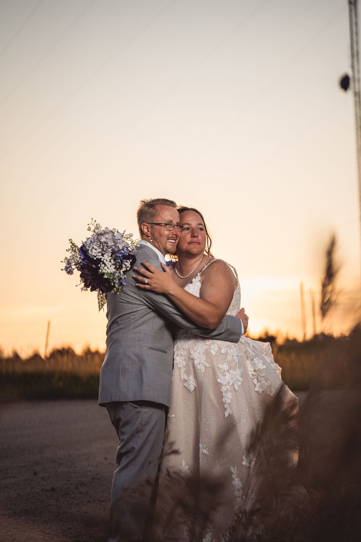 Joyful wedding couple embracing during golden hour photography session.