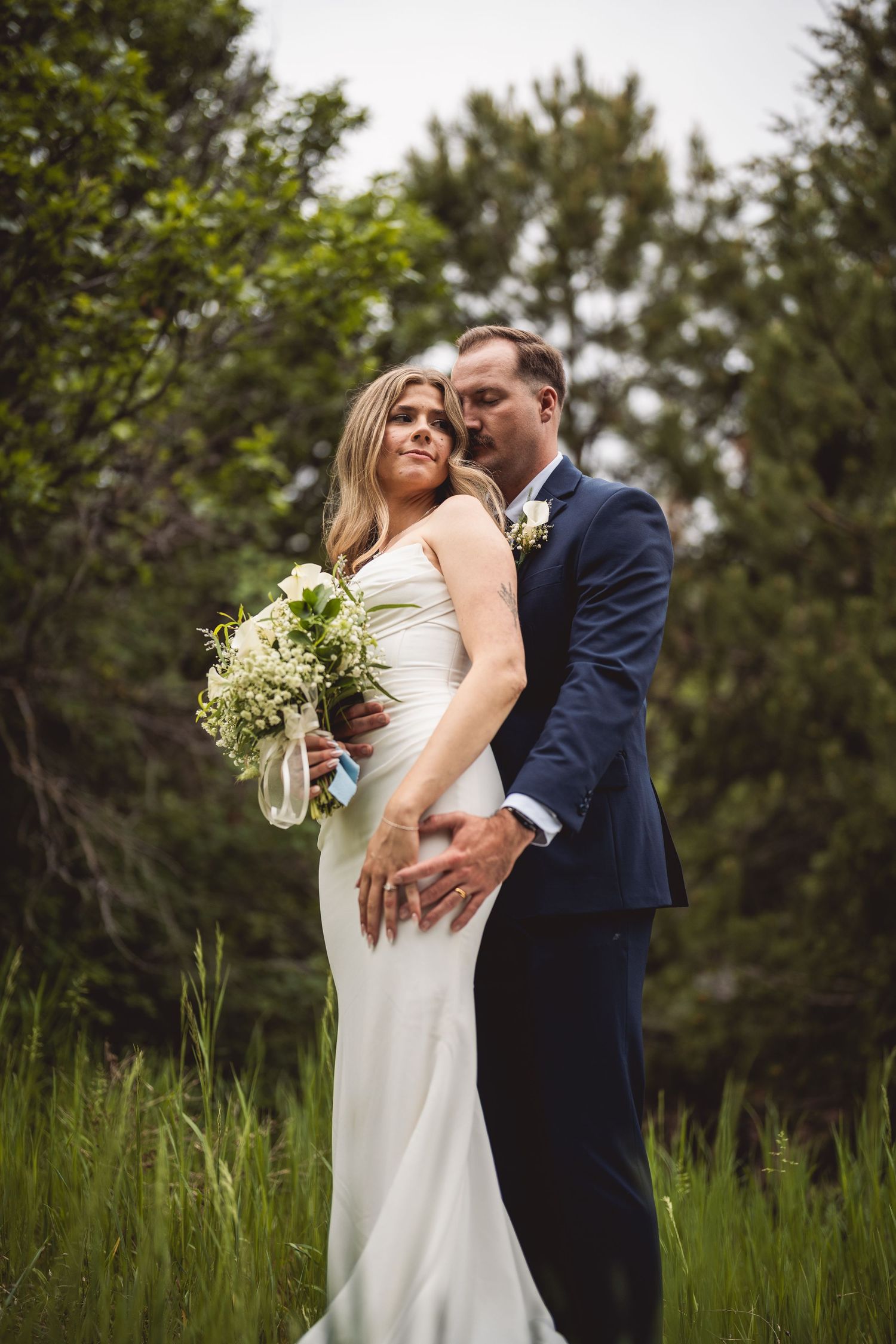 Intimate wedding moments captured in natural lighting with wildflower bouquet details.
