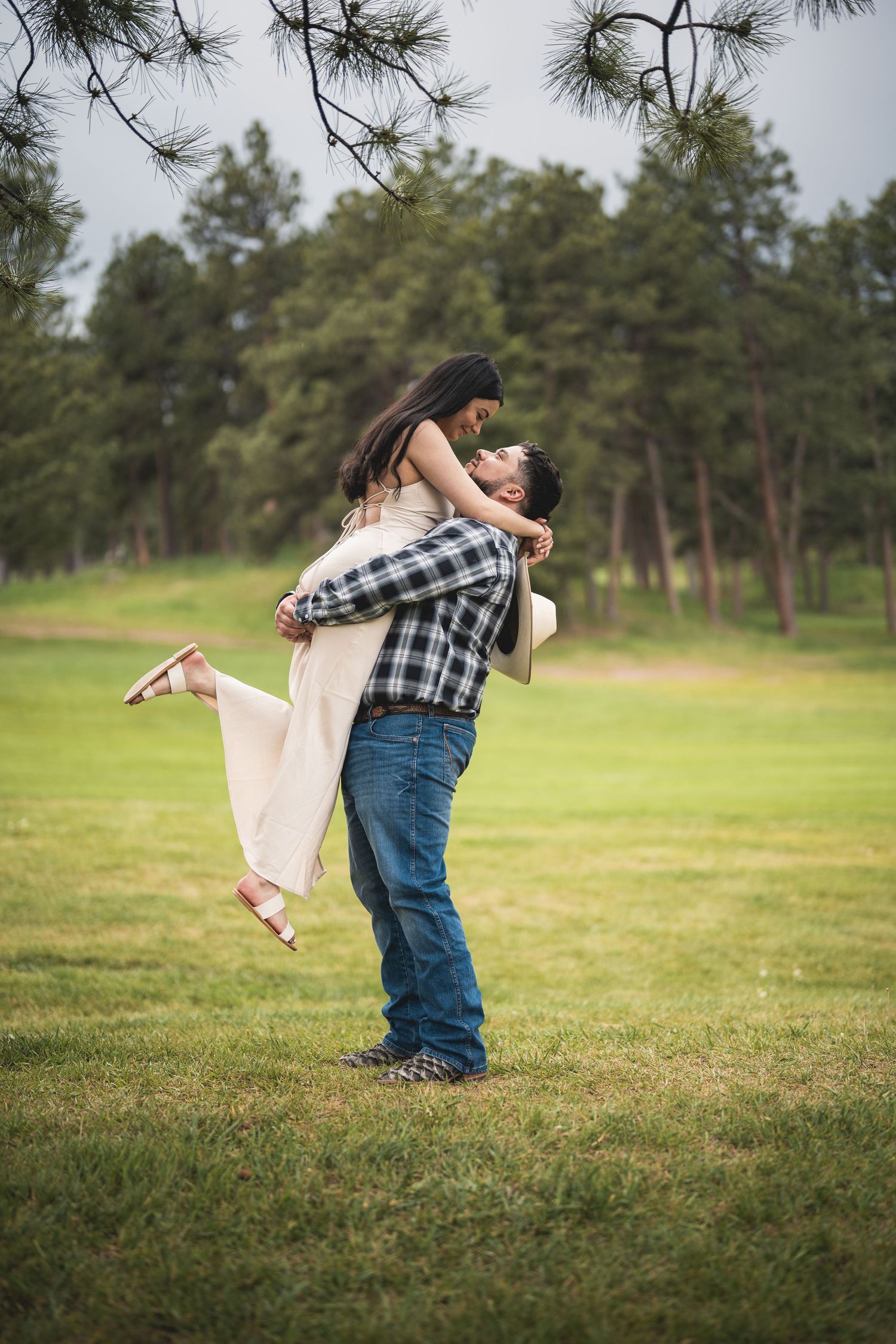 Playful sequence of dance moves in a grassy field with pine trees.