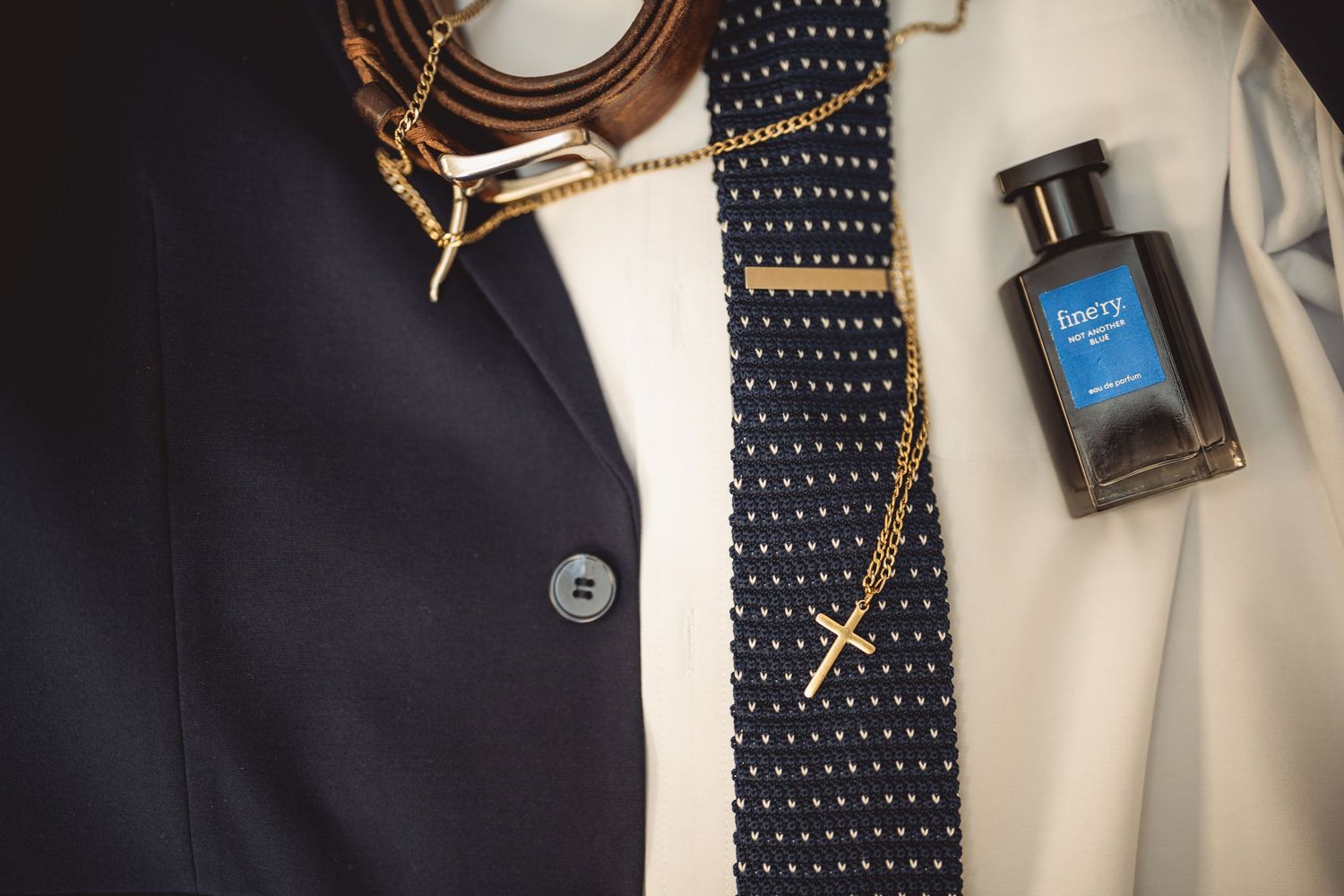 Close-up of men's formal accessories including polka dot tie and suit buttons.