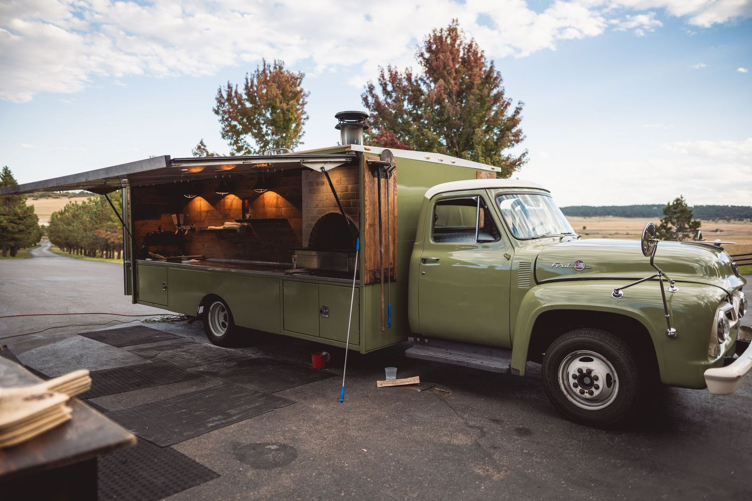 Classic mint green vintage truck parked outside rustic wedding venue.