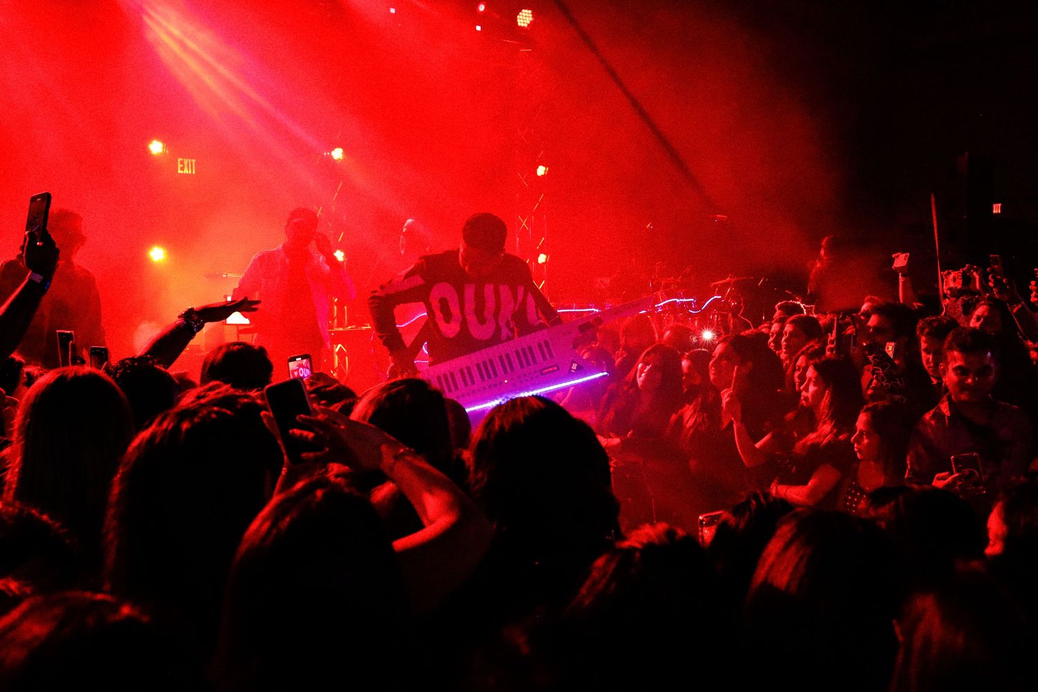 Musical show. A man playing an instrument under flashy lights. crowd cheering.