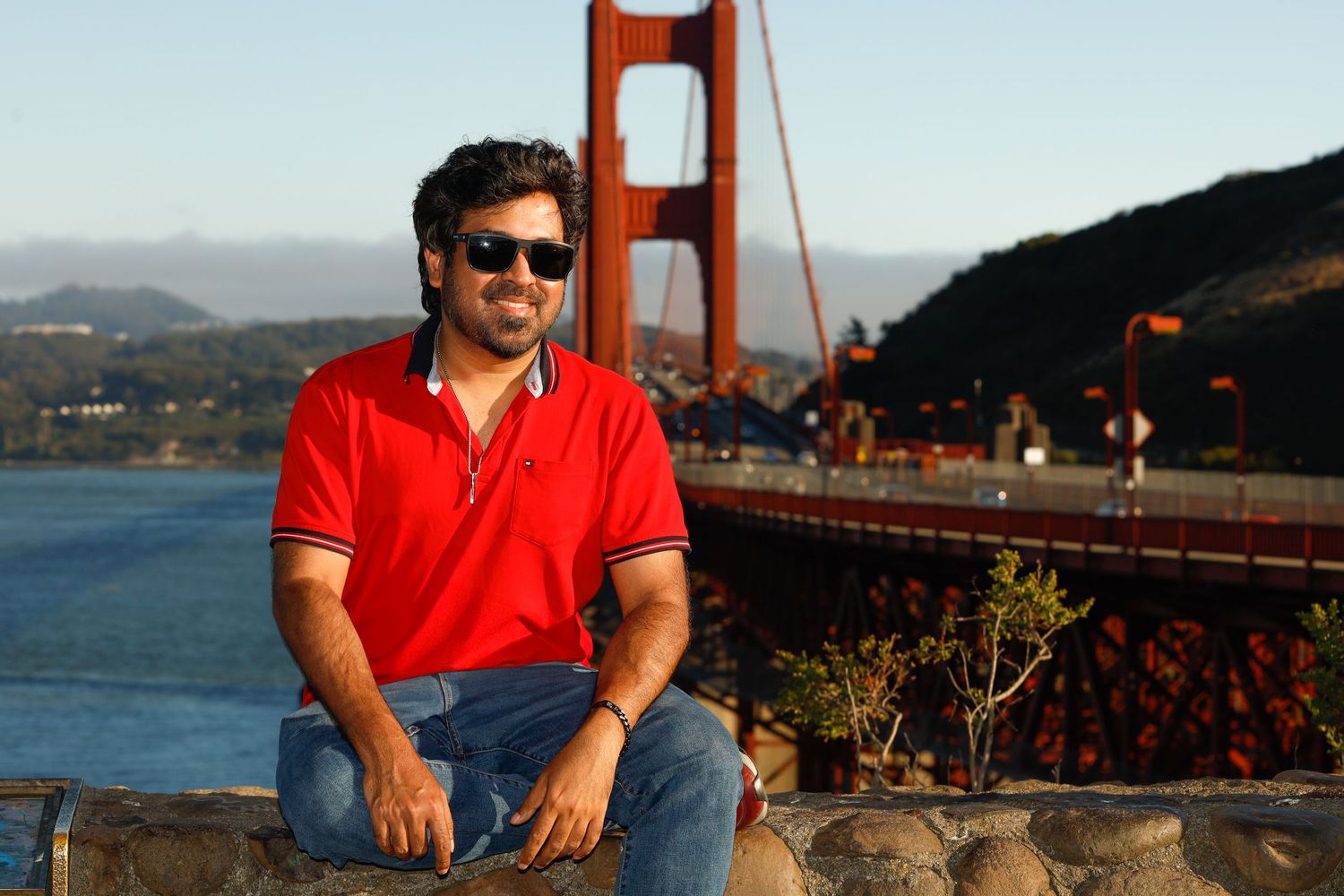 A man sitting in front of the golden gate bridge.