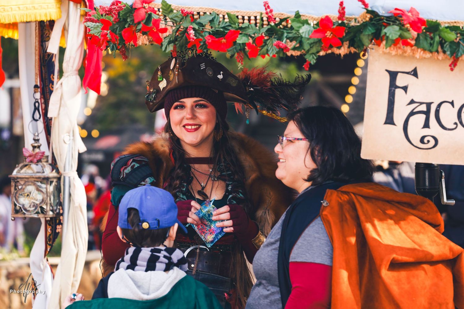 A girl wearing renaissance style costume. a woman and a kids at the foreground.