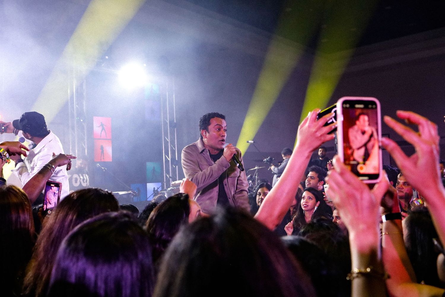 Musical show. A man singing under flashy lights. crowd cheering.