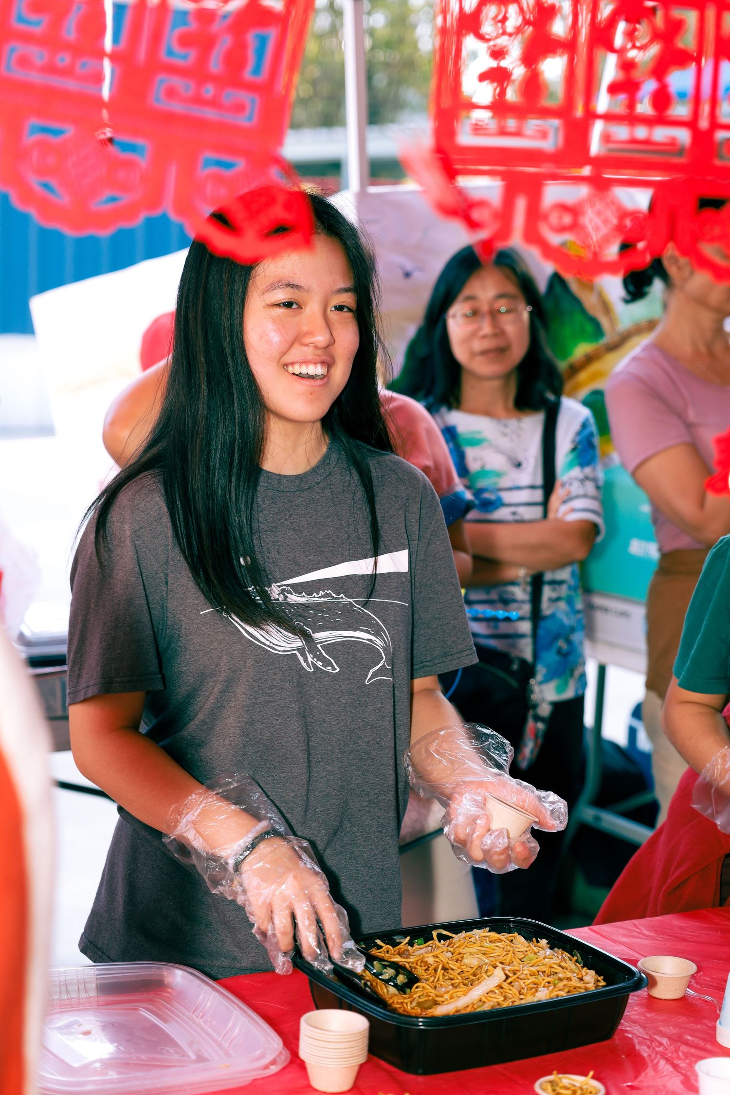 school international festival. A female serving food at a country booth