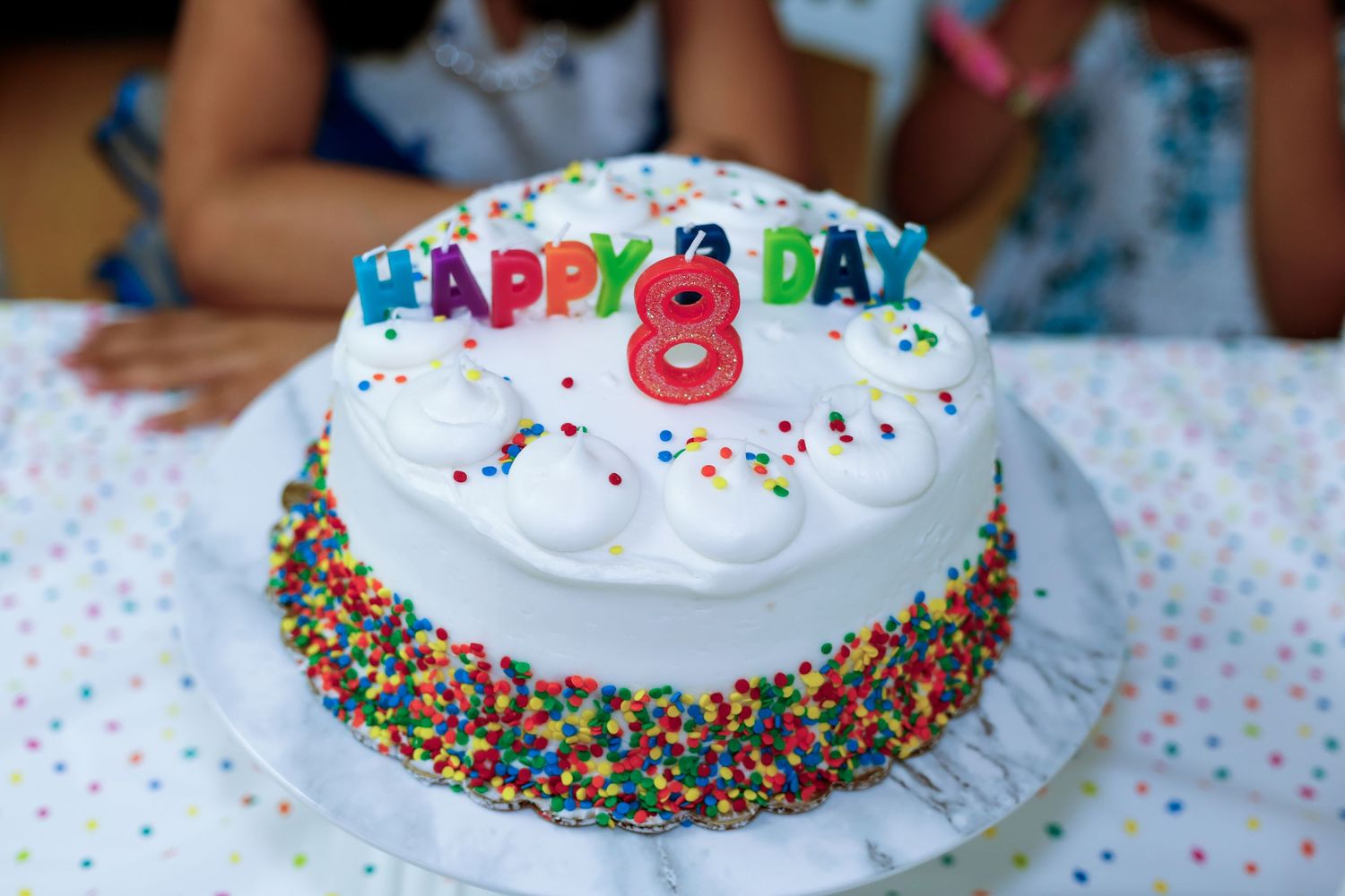 White birthday cake. A red candle shaped number 8 on top of the cake.