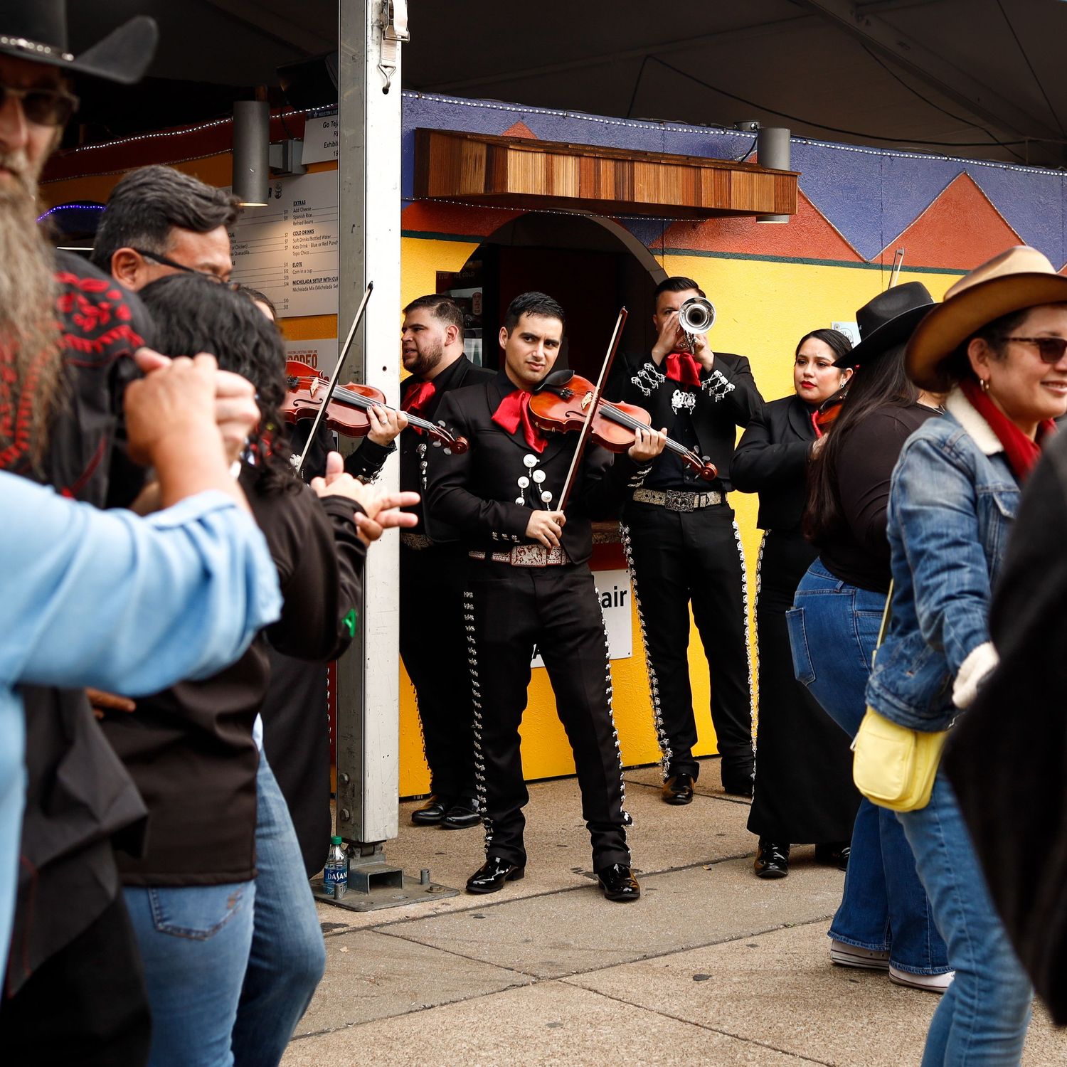 A group of people playing musical instruments outdoor.