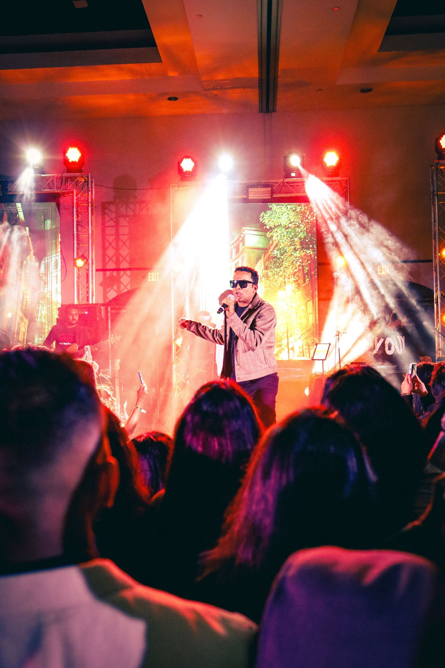 Musical show. A man singing under flashy lights. crowd looking.