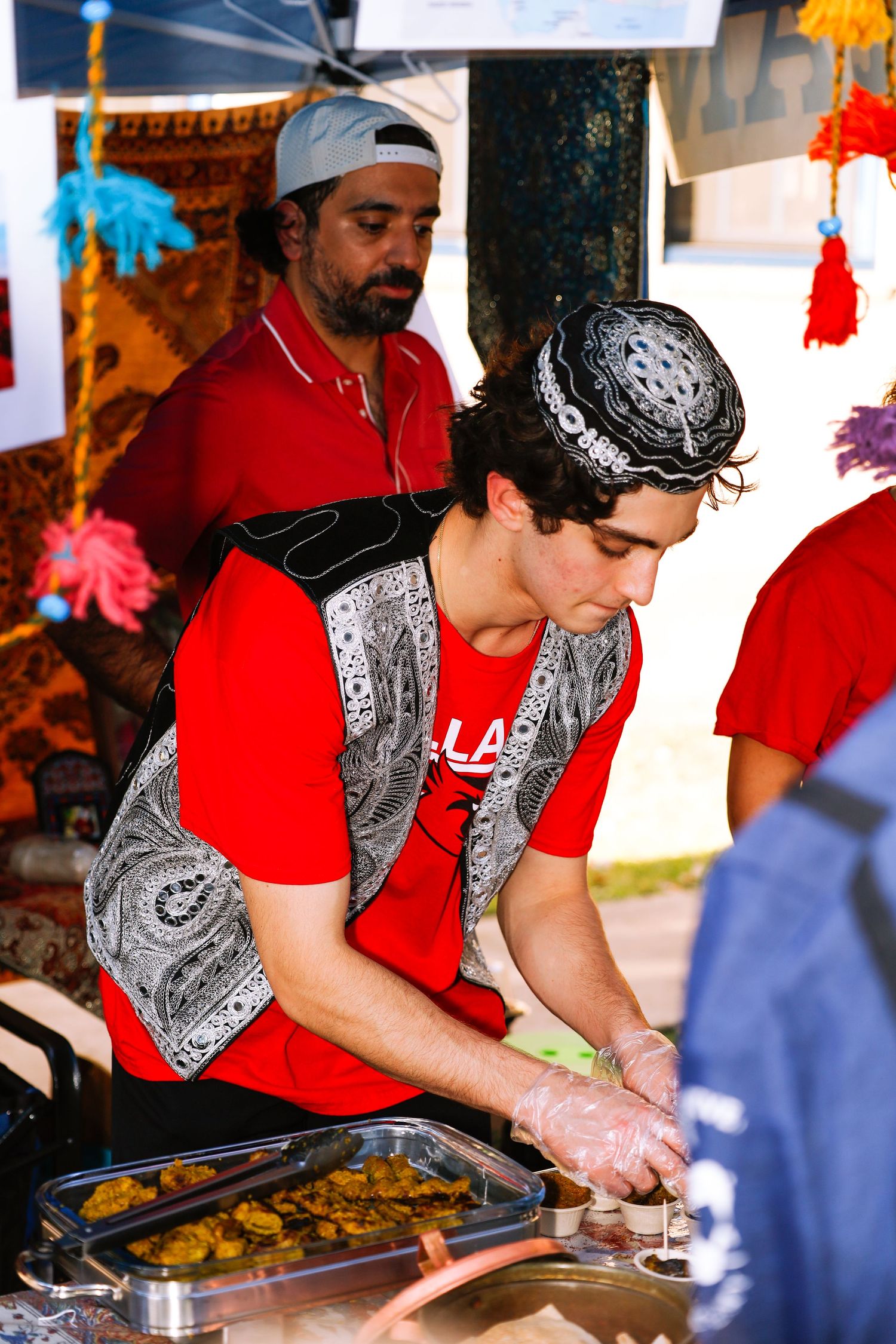 school international festival. A man preparing food at a country booth