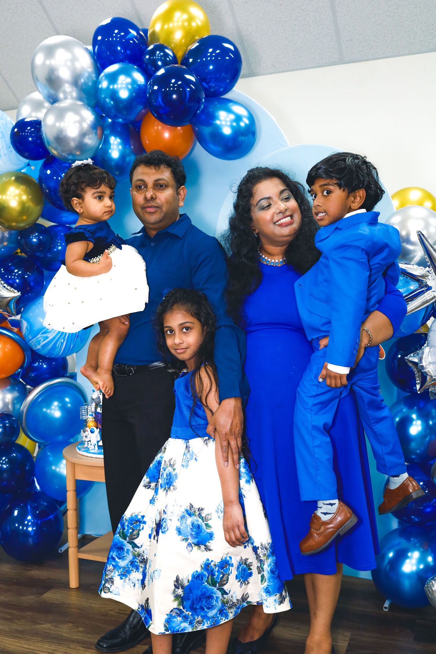 a family of five posing for a birthday party photo