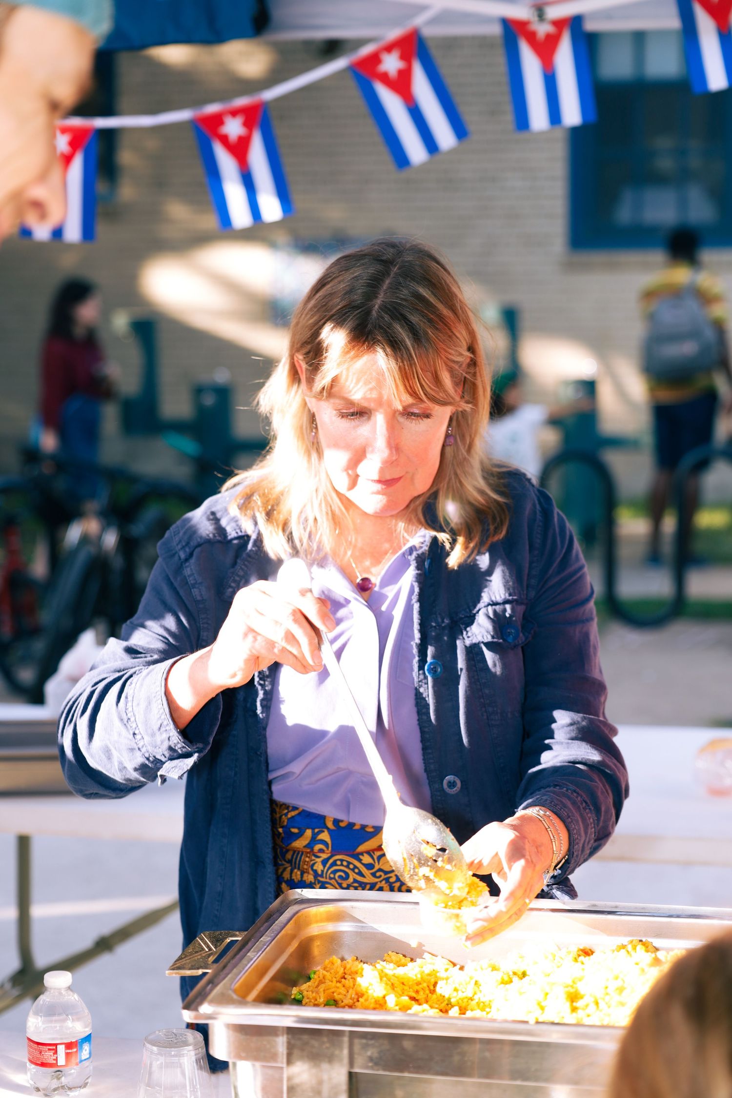 school international festival. A female serving food at a country booth