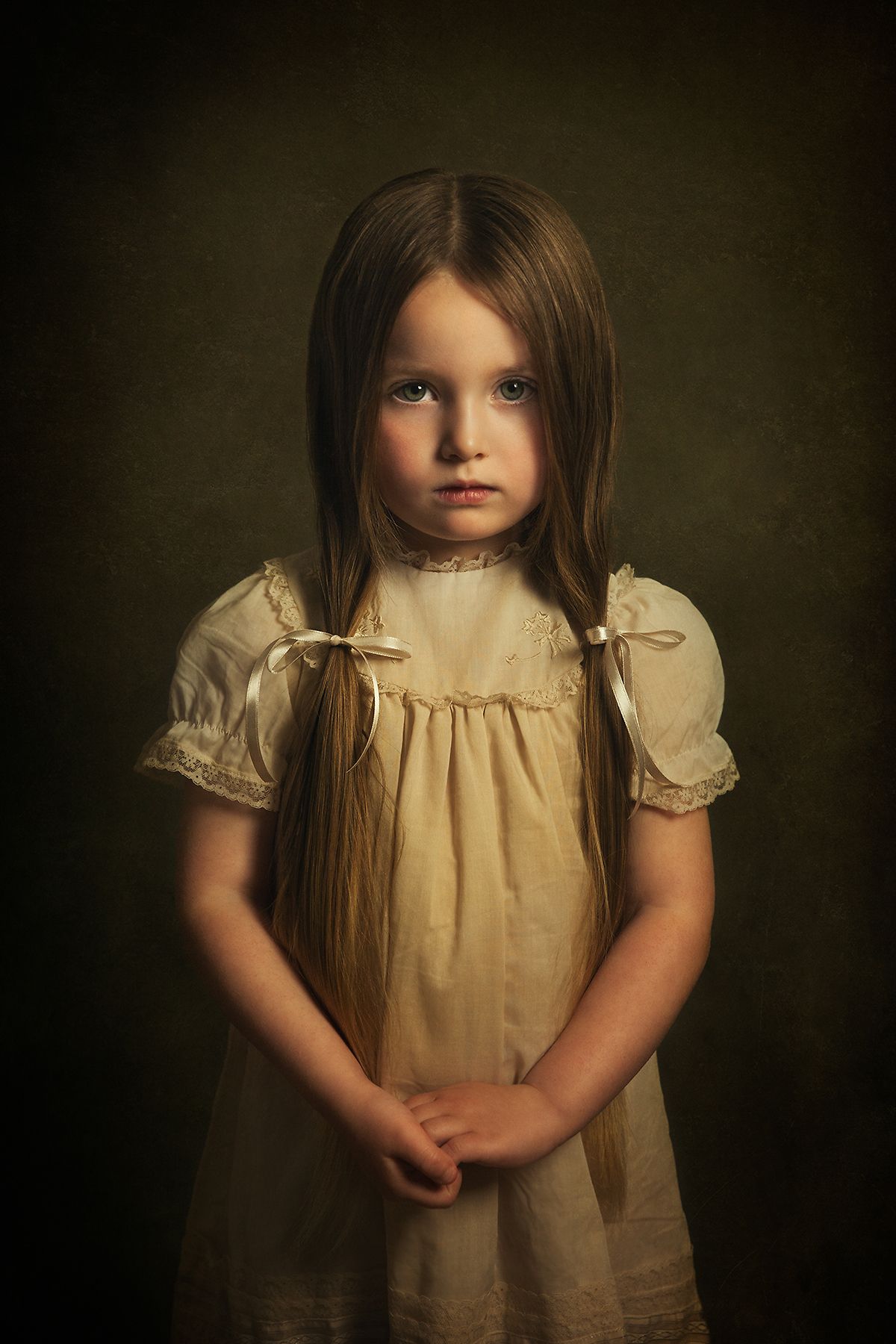 Artistic portrait series in vintage cream dress against dark background.