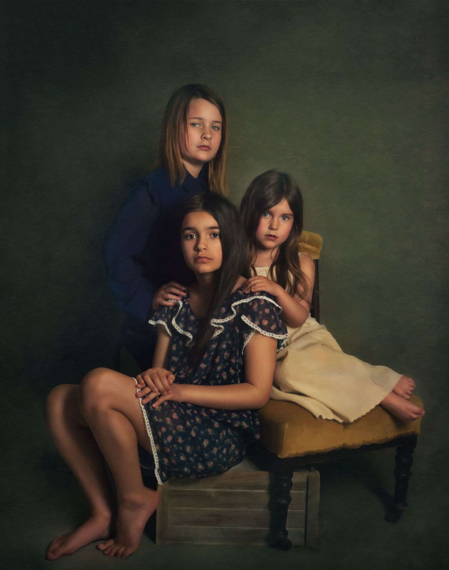 Vintage style portrait of children lounging on antique furniture in moody lighting.