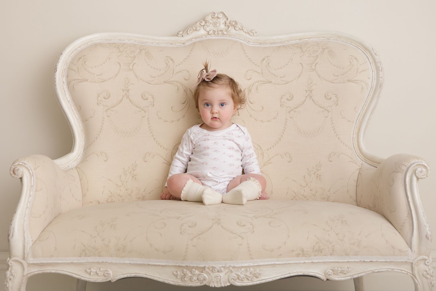 Four vintage-style photographs show a white ornate couch against a neutral backdrop in different compositions.