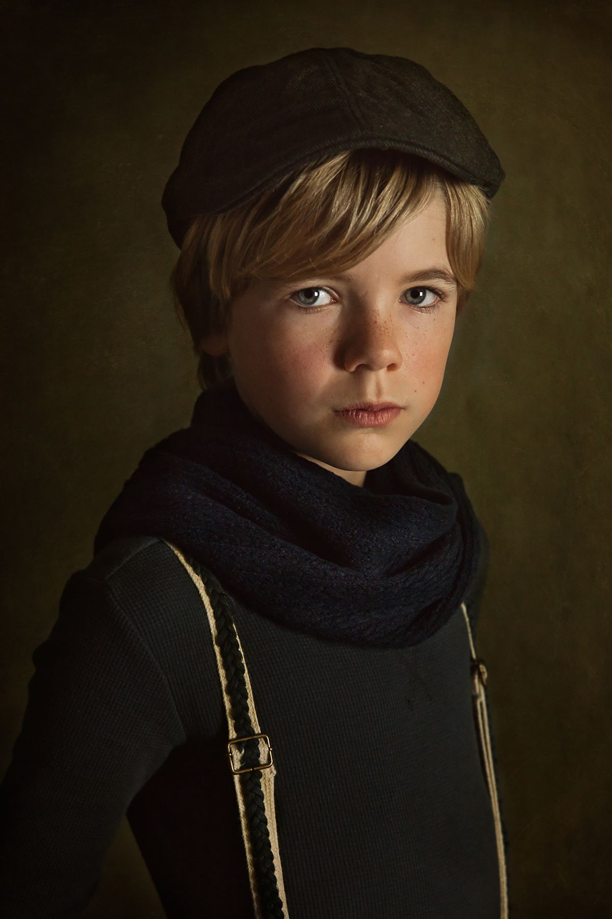 Moody portrait featuring a navy scarf and cap against a dark green background.