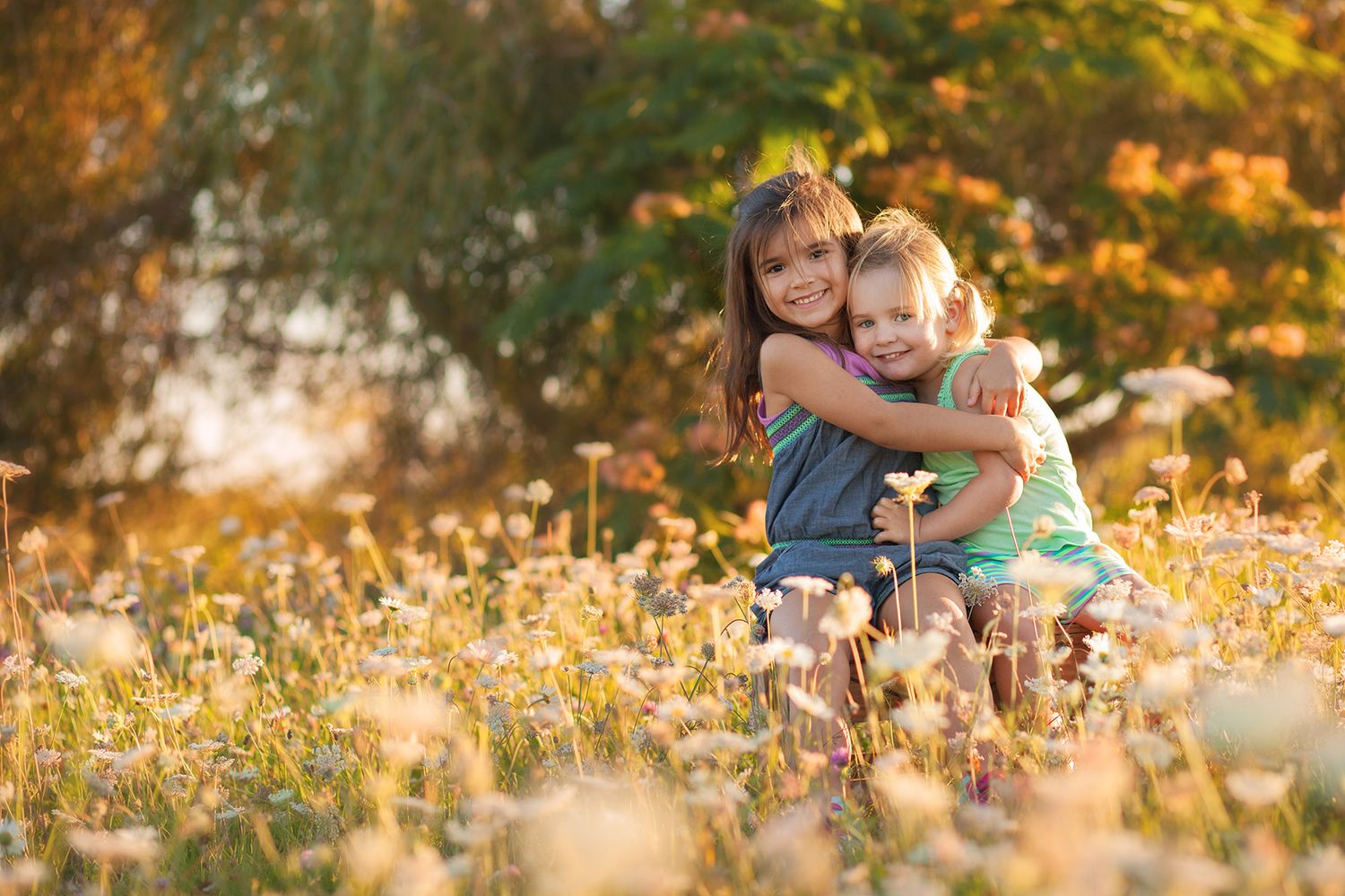 A child plays joyfully in a field of golden autumn leaves during a warm sunset.