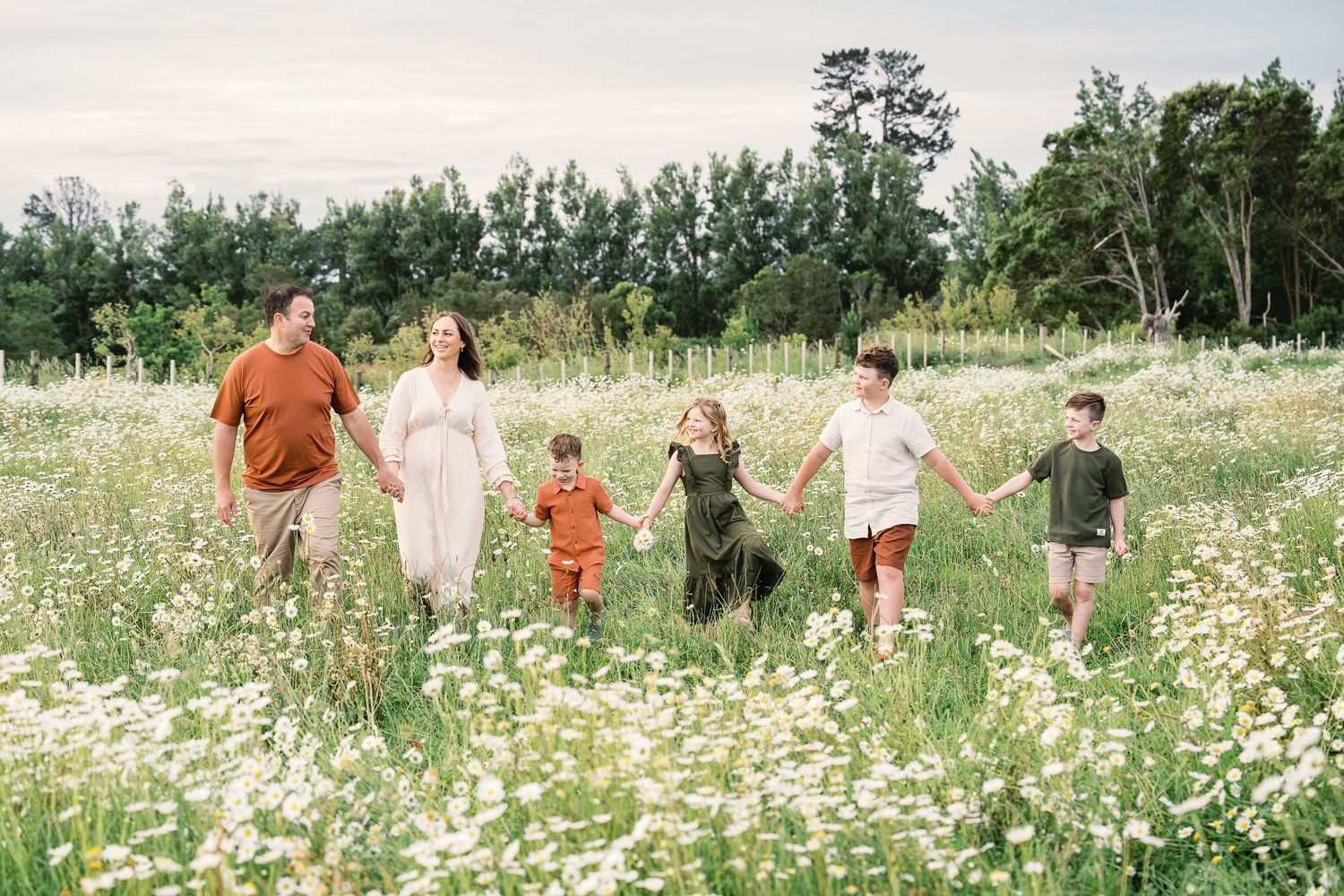 A group of people walking through a blooming wildflower meadow on a sunny summer day.