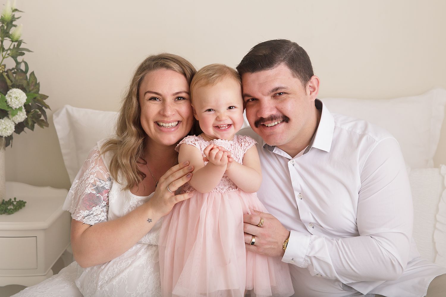 Intimate family photography session featuring soft pastel colors and natural poses.